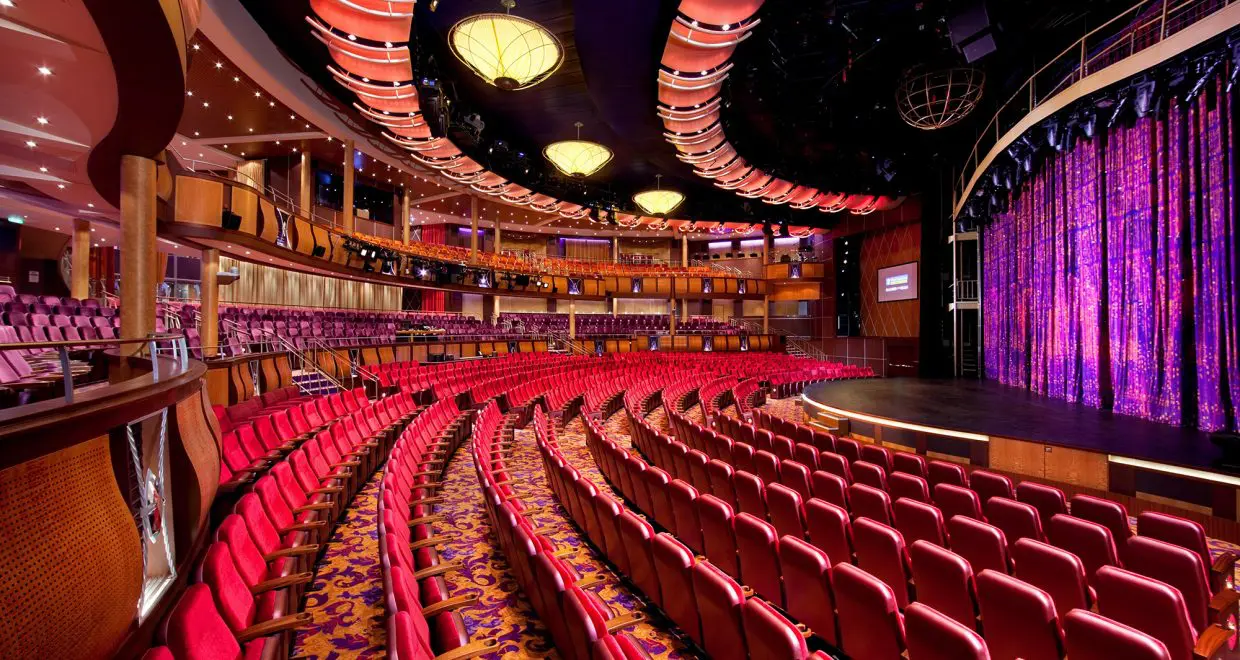 A theater with red seats and a large stage.