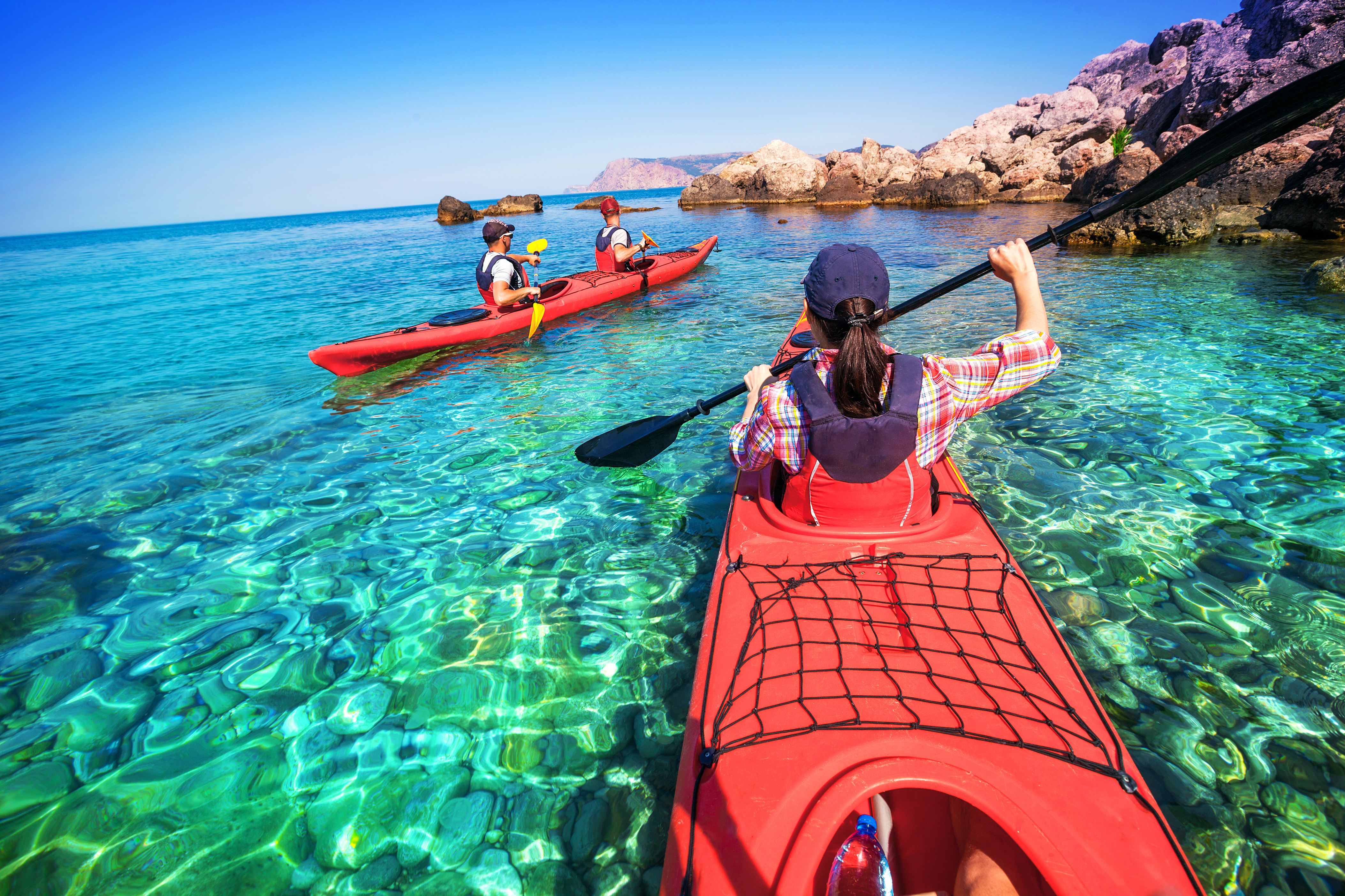 A group of people kayaking in the ocean.